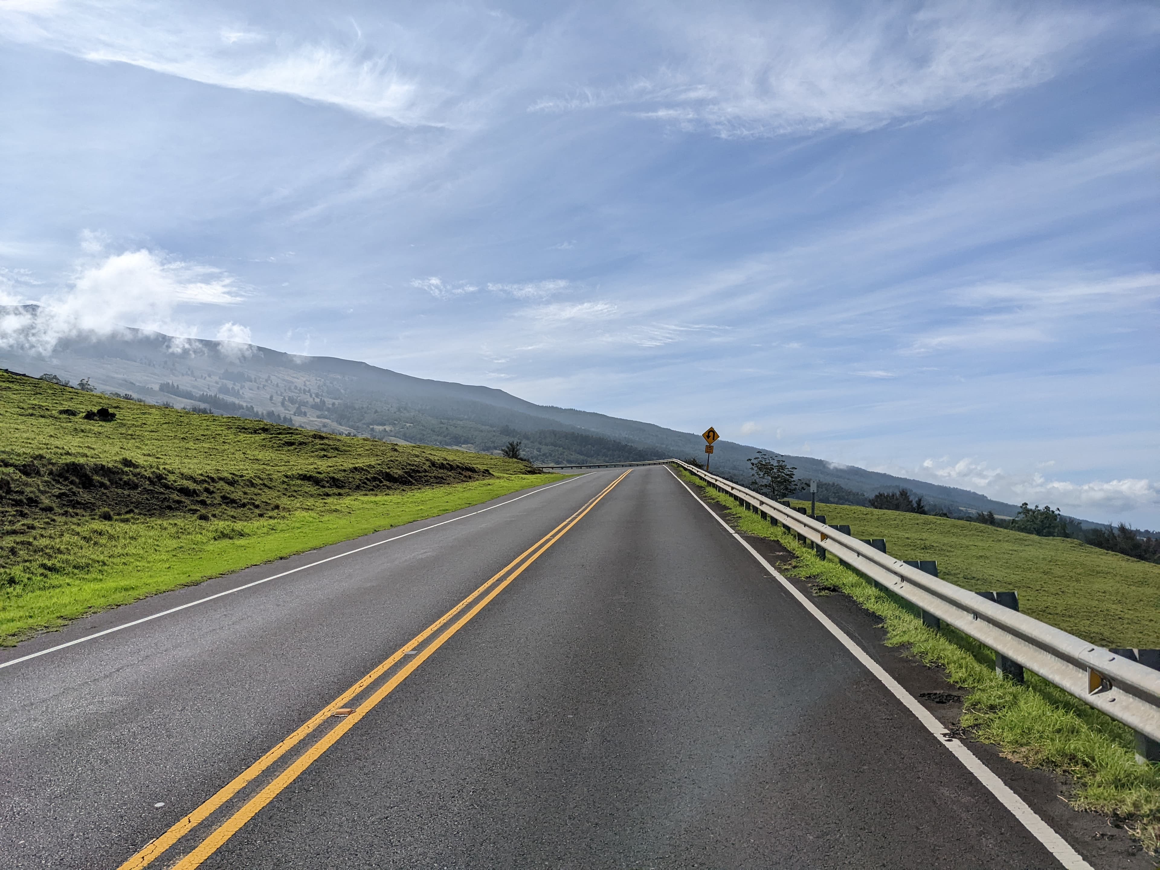 Open road through rolling green hills